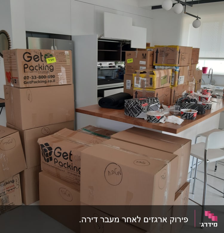 קופסאות קרטון מסודרות במטבח, מוכנות לפריקה